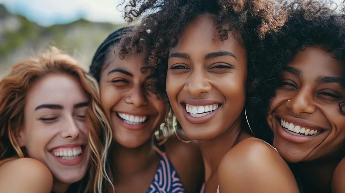Cuatro amigas riendo juntas al aire libre